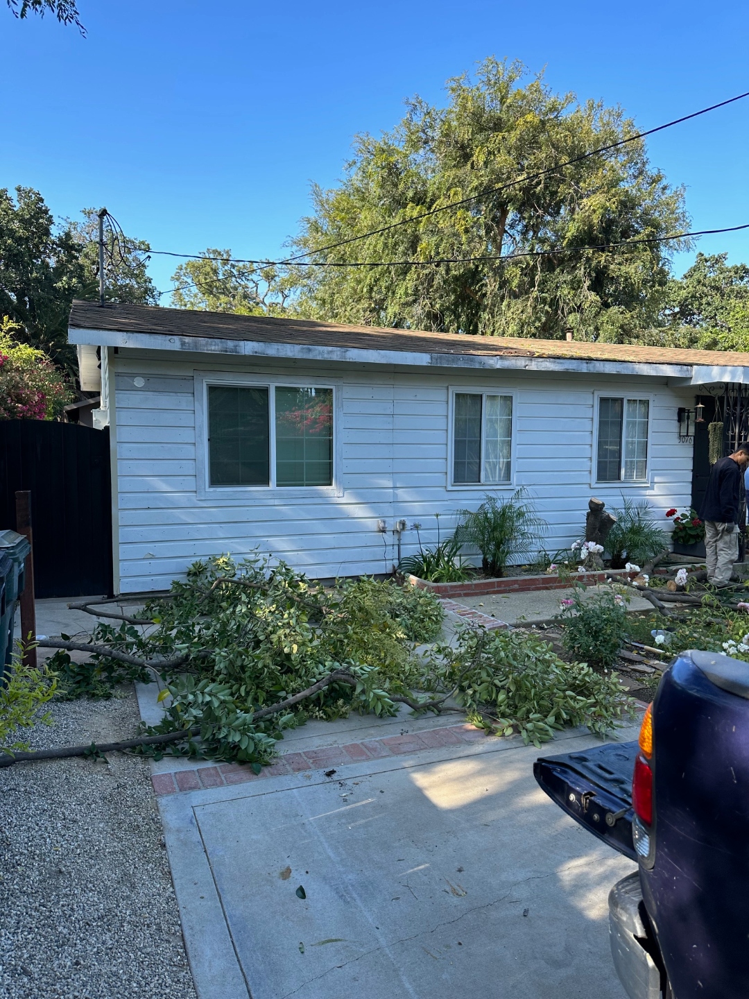 Before: original white lap-siding Thousand Oaks residence with tree debris cleared